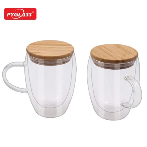 Two double-walled transparent glass mugs with bamboo lids, displayed side-by-side with a visible brand logo in the background.