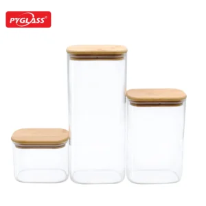 Set of three clear glass storage jars with bamboo lids, featuring different sizes for versatile storage options.